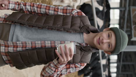 vertical portrait of boy drinking fresh milk at farm