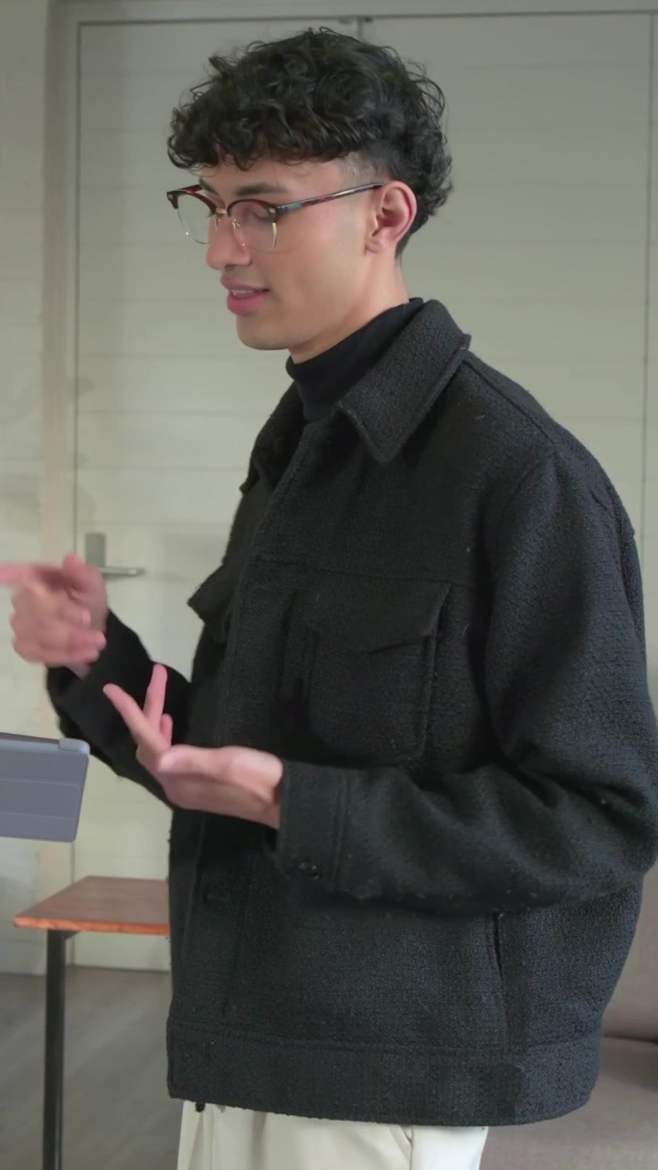 Vertical video: Being handed tablet man glasses jacket reviewing with peer in lounge, copy space