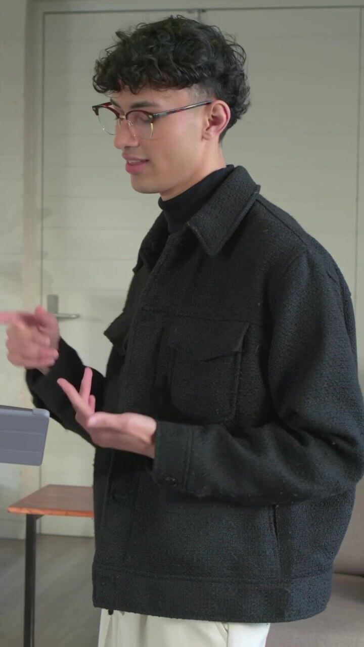 Vertical video: Being handed tablet man glasses jacket reviewing with peer in lounge, copy space