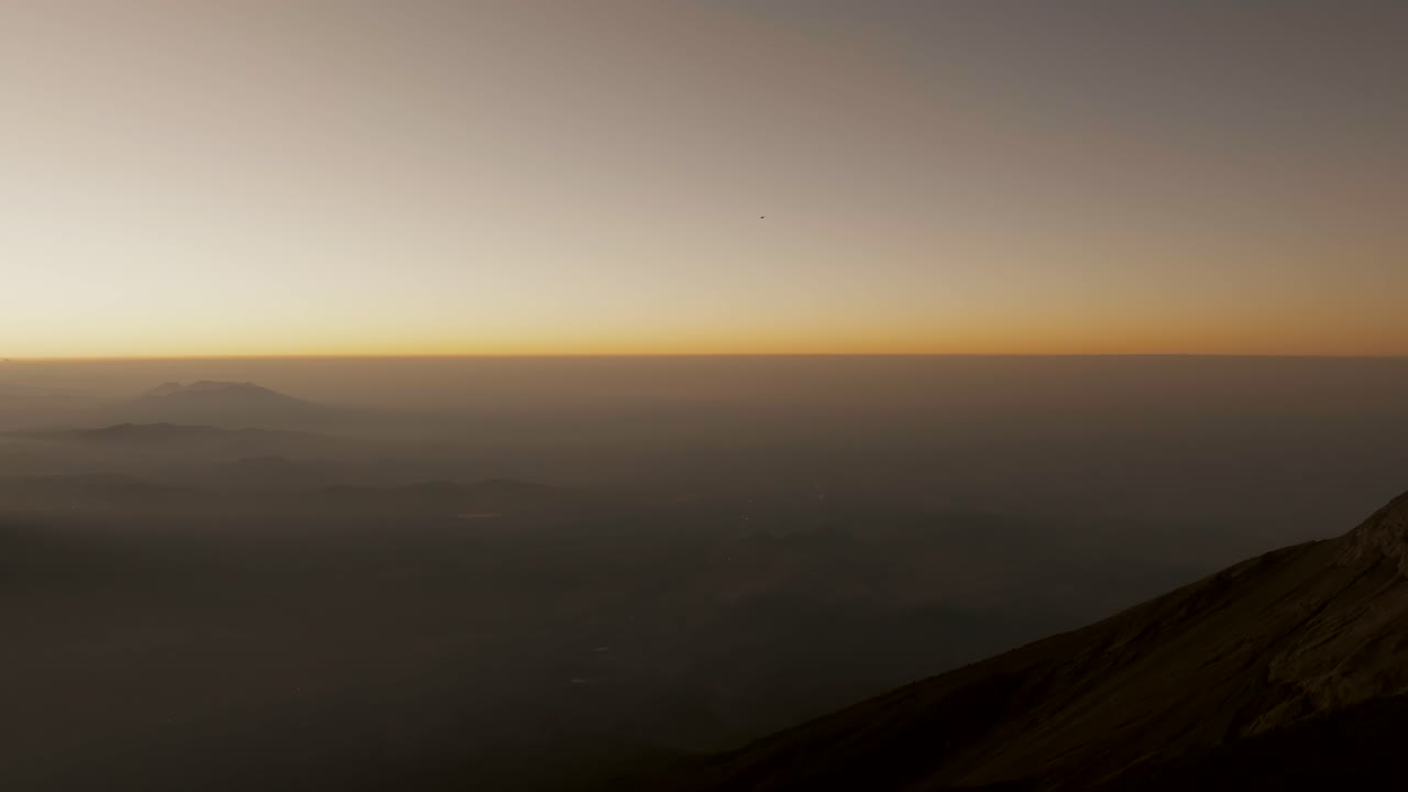 과테말라 의 해가 뜨는 동안 아카테난고 화산 꼭대기에 서 있는  ⁇ 발 을 들고 있는 하이커