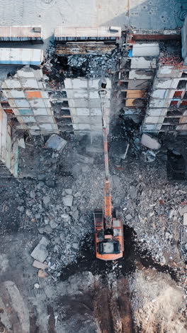 demolition of building for new construction by excavator bucket. demolition of the house. city development. view from above. vertical video