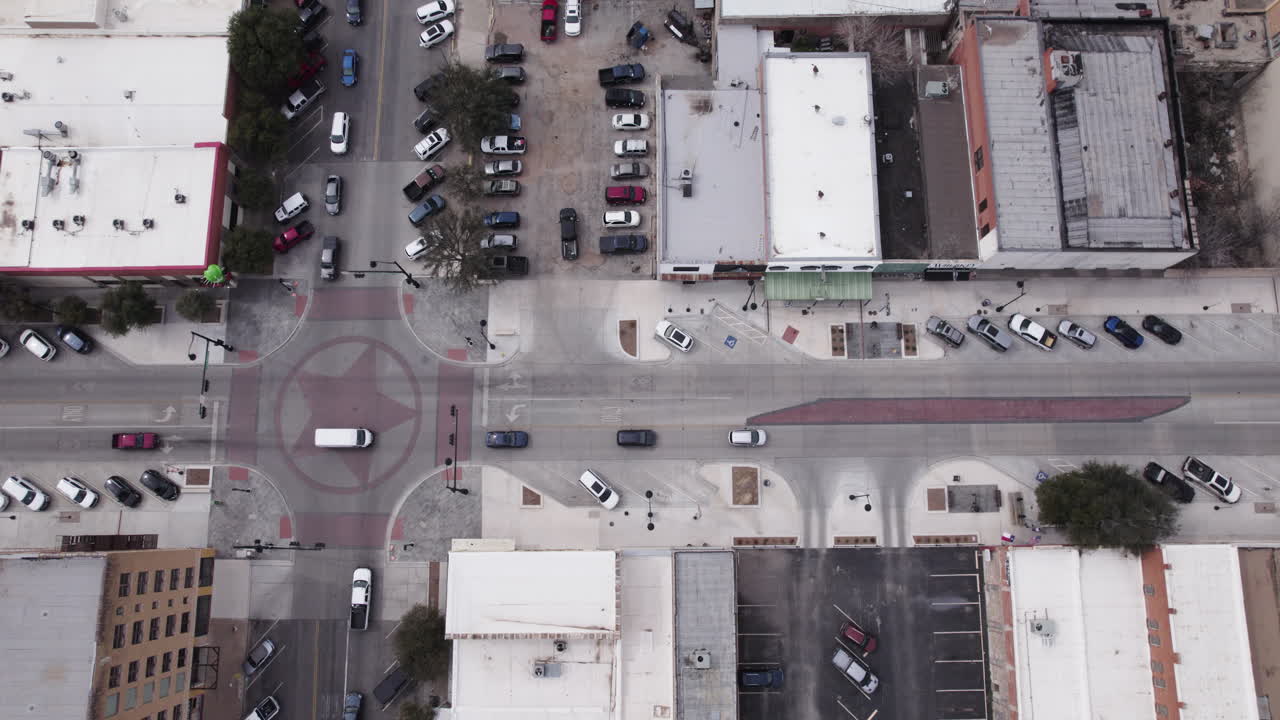 Busy downtown intersection in San Angelo, Texas, traffic drives through a light
