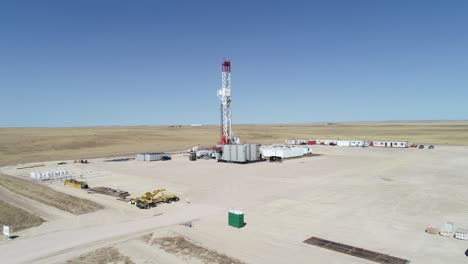 wide rising semi orbit drone shot of a big rig to reveal other rigs in the same field