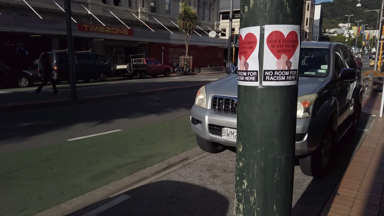 Tilt reveal showing sign "No Room for Racism" after national tragedy.