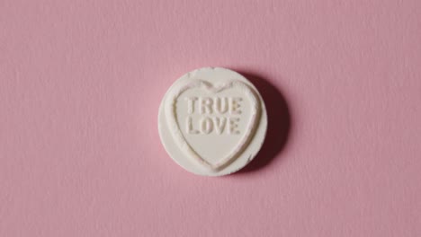 heart candy with true love message on pink background