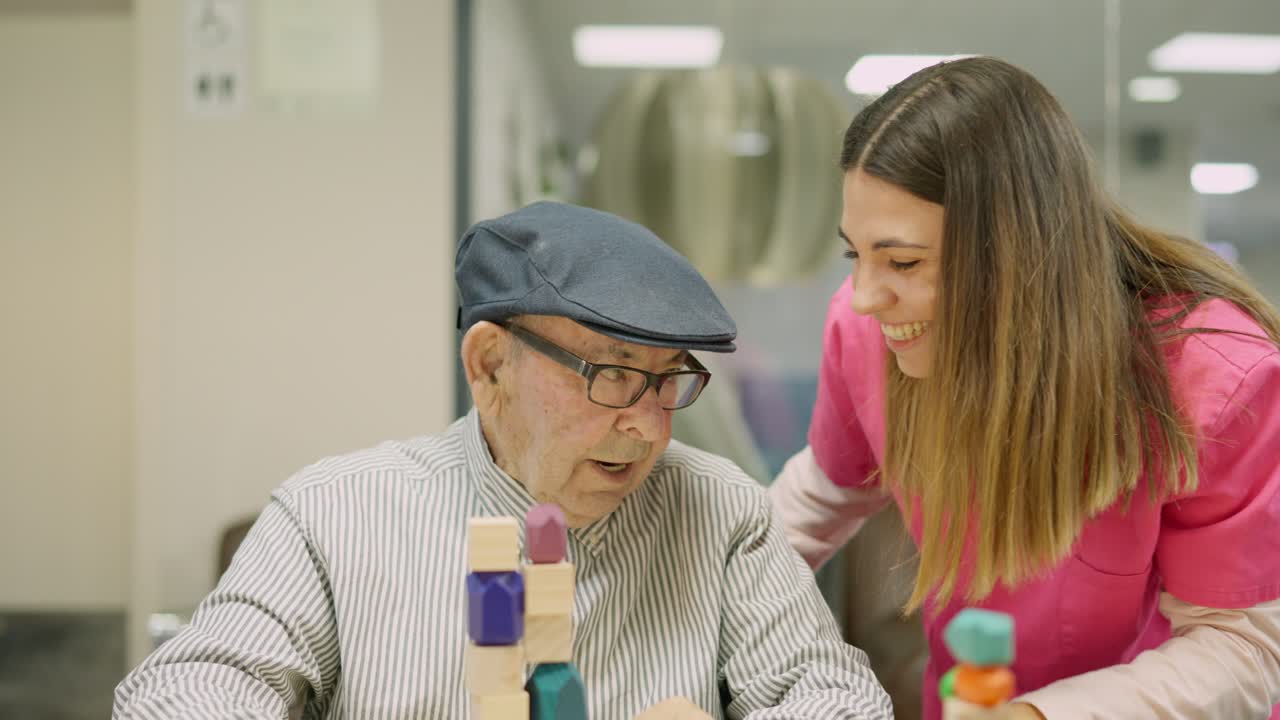 Elderly man playing stacking blocks with caregiver