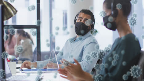 animation of covid 19 cells over man and woman in face masks in office