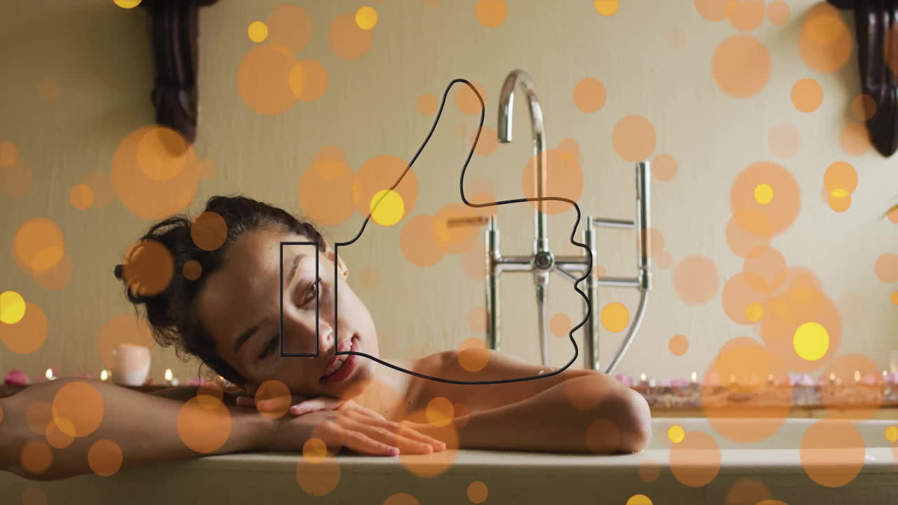 woman leaning head on folded arms in bathtub showing floating bokeh and candles for wellness