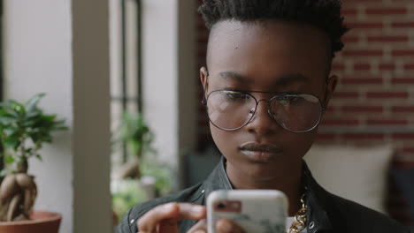 stylish young african american woman using smartphone at home student browsing social media messages texting on mobile phone enjoying sharing trendy lifestyle online wearing glasses