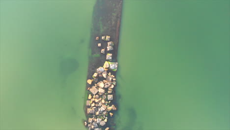 a submerged barge next to the seashore