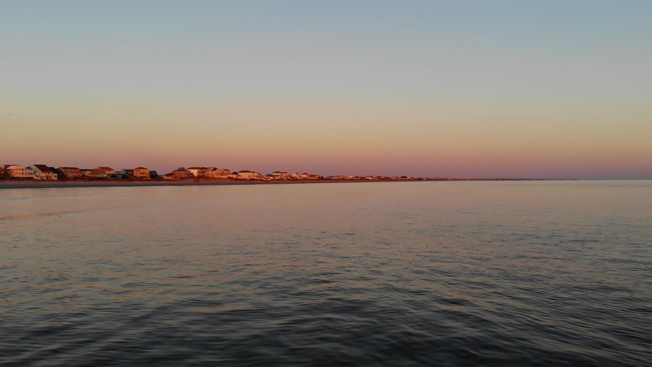 empuje un dron aéreo cinematográfico que vuela a baja altura sobre las olas del océano al atardecer