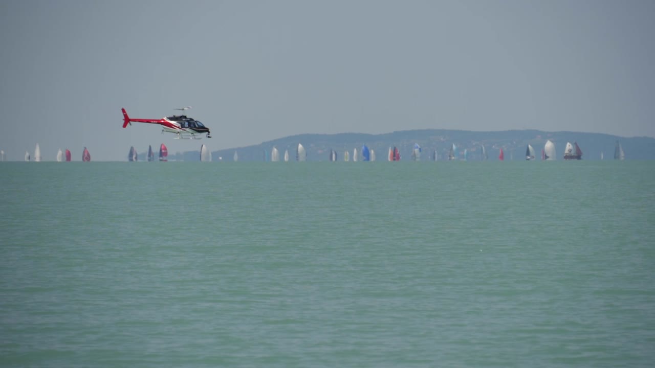 kékszalag 그랑프리에서 발라톤 호수 위를 날고 있는 미디어 헬리콥터 - 슬로우 모션