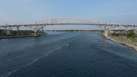 boat in st clair river with blue water bridge, port huron michigan, usa