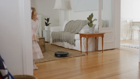 happy little girl dancing playfully with robot vacuum cleaner funny child pretending to be ballerina having fun playing dress up wearing fairy wings ballet costume at home 4k