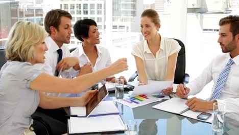 Happy-business-people-going-over-figures-at-meeting