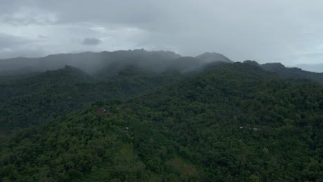 Vista-Aérea-De-La-Niebla-Que-Lentamente-Envuelve-Los-Bosques-En-La-Cordillera-Por-La-Mañana