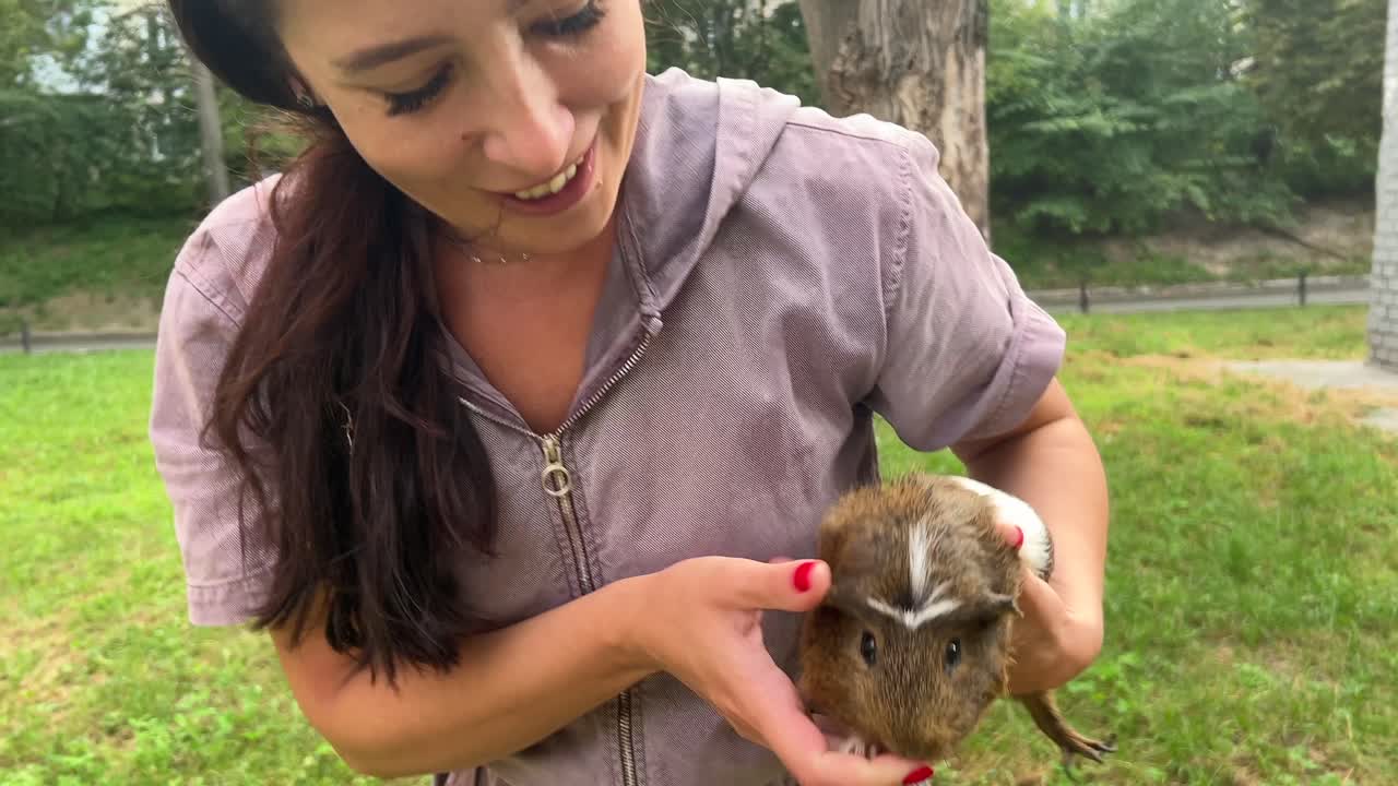 공원에서 기니피그를 들고 있는 여자