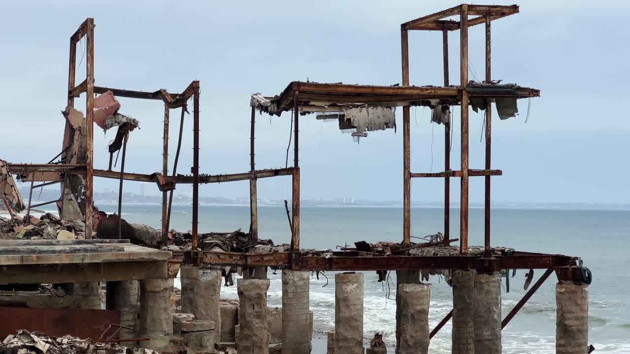 Handheld long lens booming down shot of a beachfront home burned by the Palisades Fire in Malibu, California. 4K