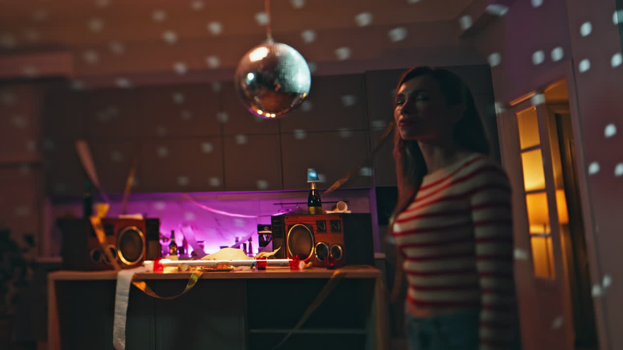 Carefree girl dancing alone after night party in apartment. Lady listening music