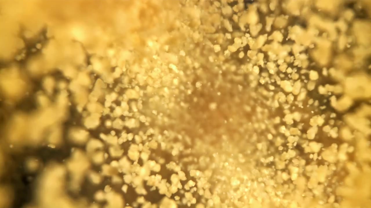 ダイナミックに渦巻く抽象的な金色の粒子