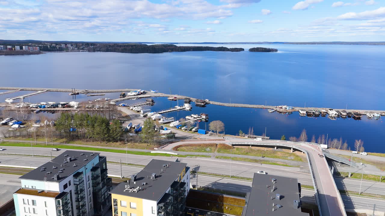 Marina and pier filled with boats. Summer day with traffic and scenic lake. Santalahti Marina in Tampere Finland and Lentävänniemi region in the background. 4K prores footage. Näsijärvi lake.