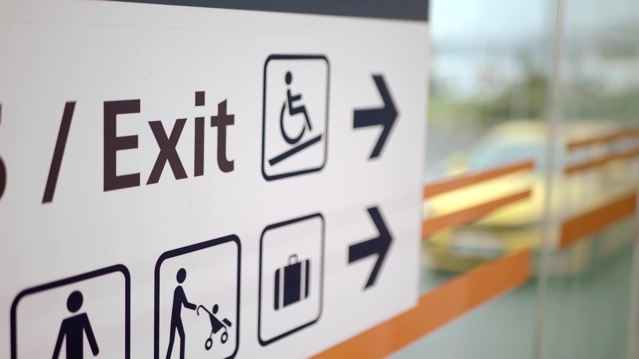 Segnale di uscita aeroportuale con icone di accessibilità e bagagli