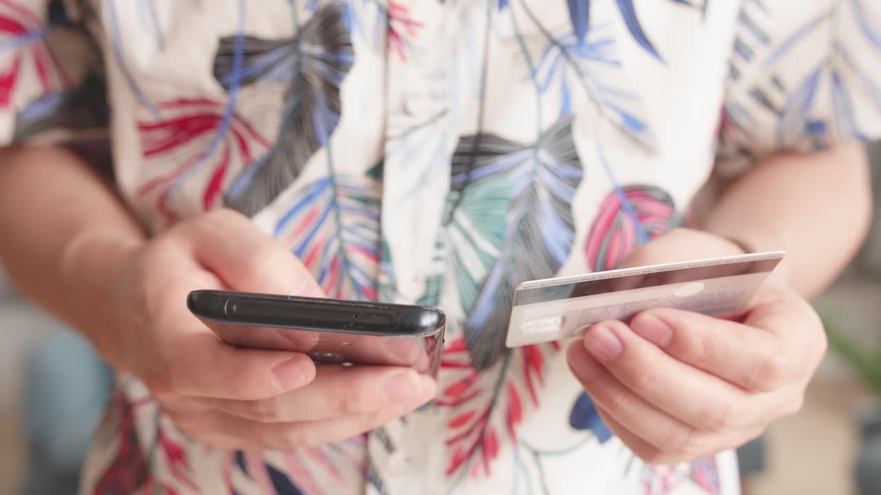 Close Up Of Man Hand Holding Smartphone And Credit Card And Doing Online Shopping At Home. Banking, Online Shopping And Lifestyle Concept