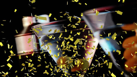 Golden-confetti-falling-over-olives-in-cocktail-glasses-against-black-background