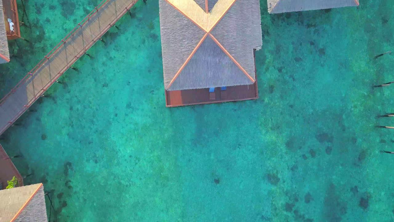 Volo aereo su un oceano turchese e cristallino e un villaggio galleggiante a Mabul, Malesia