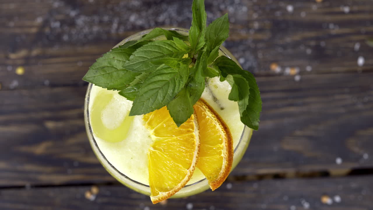 Lasillinen keltaista mintulla maustettua limonadia puupinnalla