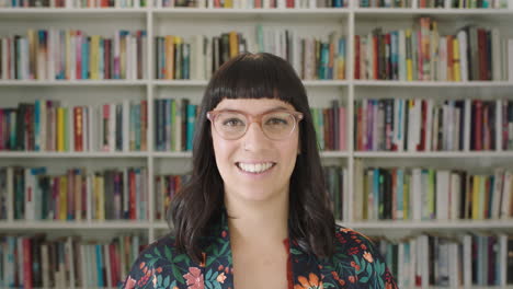 retrato de una mujer joven estudiante sonriendo estantería biblioteca universidad