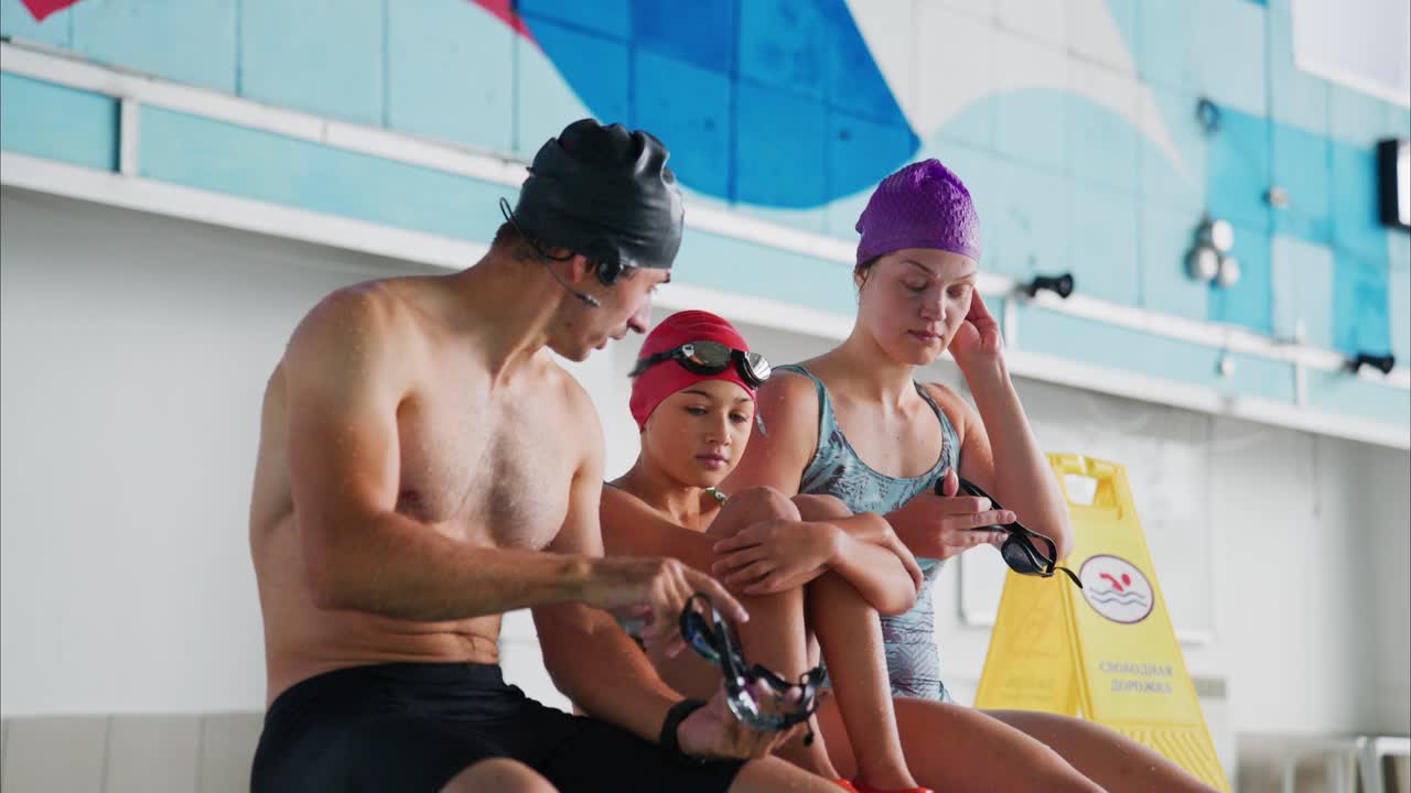 Family Bonding at the Swimming Pool: A Relaxing Moment of Preparation Before Diving into the Water with Goggles Ready for an Upcoming Swim Session