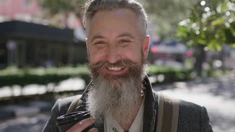 portrait-of-mature-sophisticated-bearded-man-smiling-cheerful-holding-coffee-beverage-on-city-street