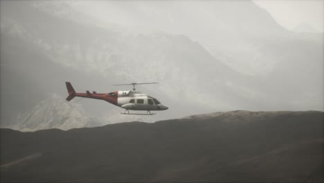 helicóptero volando en cámara lenta extrema cerca de las montañas con niebla