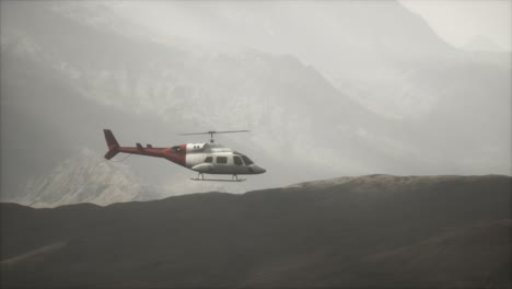 extreme slow motion flying helicopter near mountains with fog