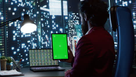 hombre de negocios mirando la pantalla verde en la tableta