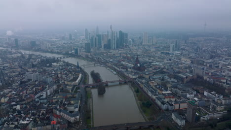 Vista-Panorámica-Aérea-De-La-Gran-Ciudad.-Puente-Sobre-El-Ancho-Río-Que-Conecta-Los-Distritos-En-Los-Bancos.-Grupo-De-Rascacielos-En-El-Centro-De-Negocios.-Fráncfort-Del-Meno,-Alemania