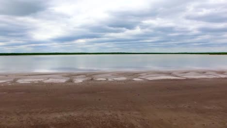 Toma-De-Un-Dron-A-La-Izquierda-En-Movimiento-De-Un-Lago-Salado-Local