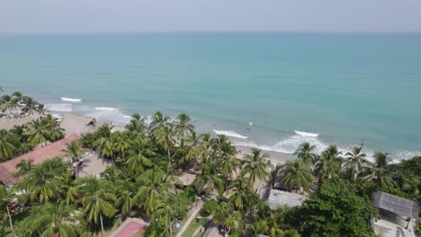 Palomino-beach,-palm-trees-and-turquoise-colored-water-in-Colombia,-Orbiting-shot