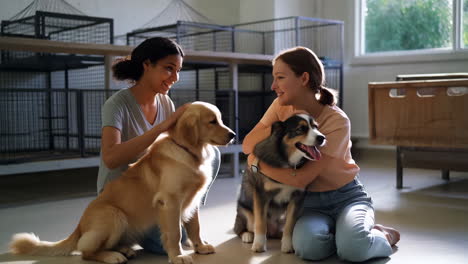 two women petting dogs