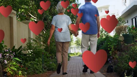 animation of falling hearts over caucasian senior couple walking