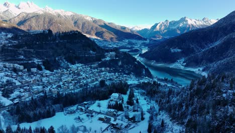 wide drone aerial view of a valley in the mountains with snow in winter in the shade