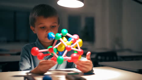 boy studying chemistry model