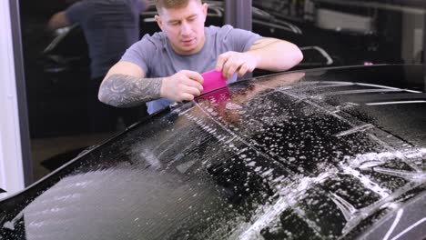 man covering car with vinyl polyurethane tape. films for the car. sticker protective film on the car