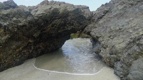 Agua-Que-Pasa-A-Través-De-Un-Arco-De-Roca-En-La-Costa-Victoriana