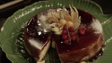 gourmet caramel flan topped with fresh berries and sugar served on green leaf shaped dish