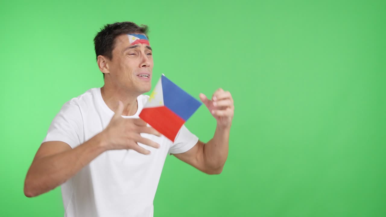 Nervous man cheering for Philippines during a match looking away