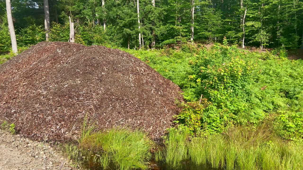 montón de mantillo a un lado de la carretera de tierra en un nuevo desarrollo
