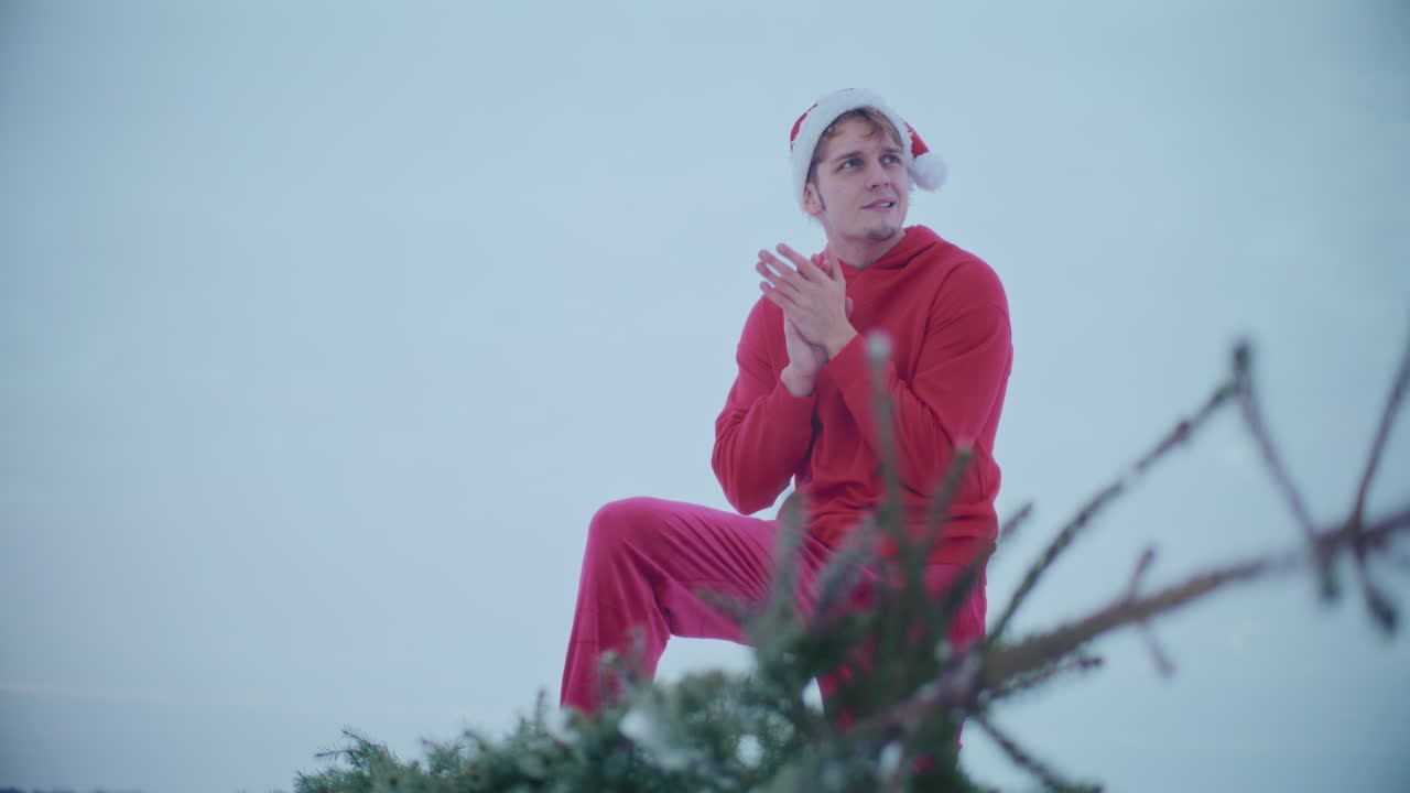 산타 모자를 입은 남자가 은 하늘을 향해 추위를 느다