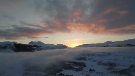 Misty-conditions-over-snow-covered-winter-landscape-at-sunset,-Arctic